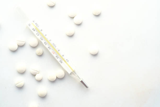istock medical thermometer and pills on white texture background 1325004050