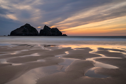 Absolutely stunning landscape images of Holywell Bay beach in Cornwall UK during golden hour sunset in Spring