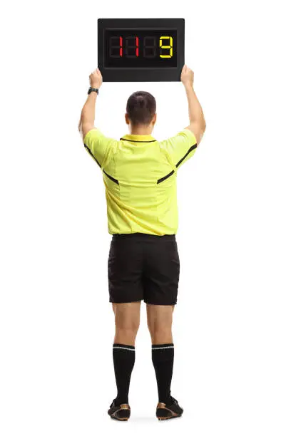 Rear view of a football referee holding a substitute board isolated on white background