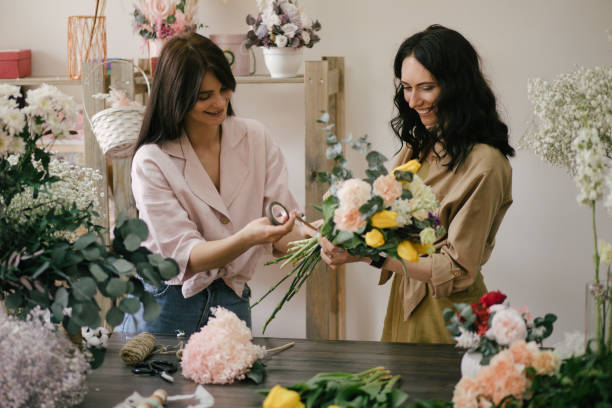 istock Two young women florist working in flower studio, making beautiful bouquet using fresh plants and flowers. 1325007185