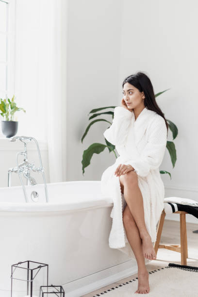istock Young asian woman bathrobe sitting on tub 1325008020