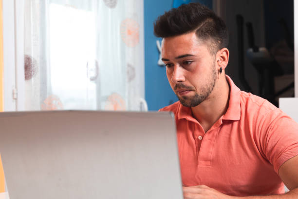 istock Young man working at home with a laptop 1325009402