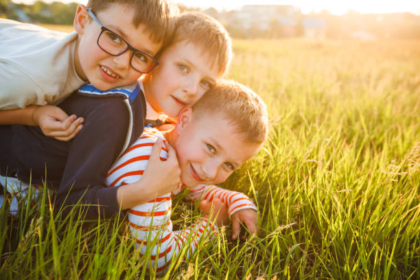 istock School-age boys lie on the grass. 1325009504
