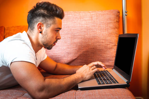 istock Young caucasian man using the laptop at the sofa 1325009637