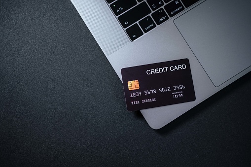 Black tinted image of credit card on laptop.