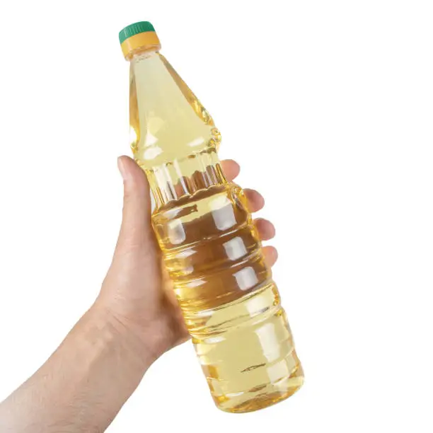 Hand with bottle of cooking oil isolated on white background.
