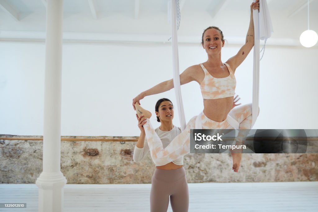 An Aerial Yogainstructor helping a pupil. Yoga and Pilates
Barre fit Aerial Yoga Stock Photo