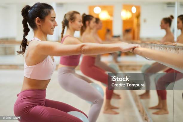 Barre Fit Exercise Class Group Of People In A Row At A Barre Workout Class Stock Photo - Download Image Now