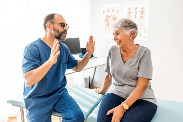 istock Confident mature male chiropractor talks with new patient 1325013910
