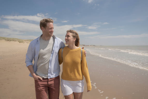 istock Caucasian couple walking at water’s edge on beach holiday 1325013920