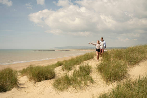 istock Young woman admiring bay view from sand dune 1325013936