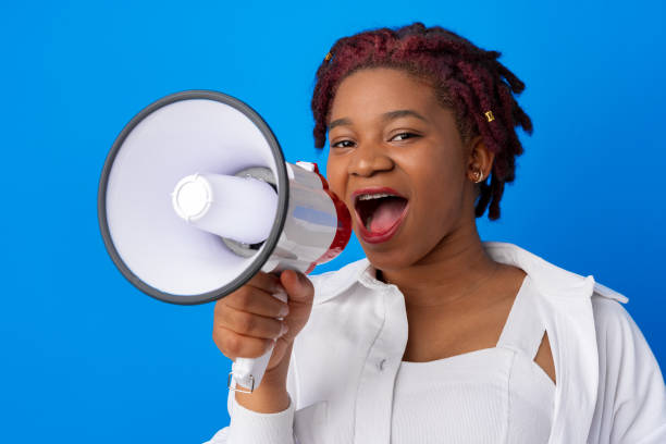 istock African american woman using megaphone against blue background 1325013974