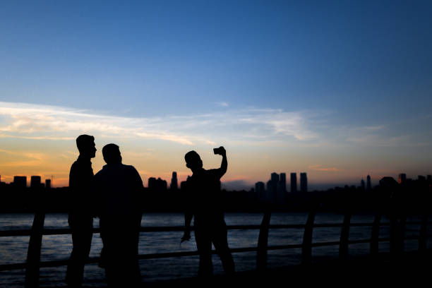 Young men taking photos of magnificent sunset view