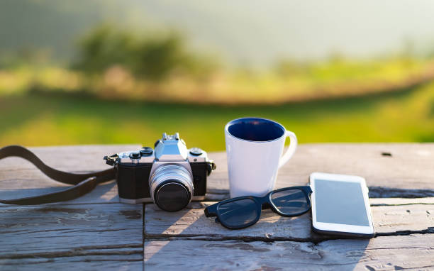 чашка с чаем на столе над горами пейзаж с солнечным светом старинные. красота природы фоне кофе рядом со старой фотокамерой на деревянном с� - кофе брейк стоковые фото и изображения