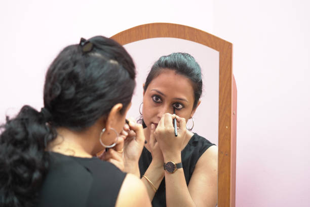 istock A lady in 30s putting leye liner make up in front of a mirror. 1325021237