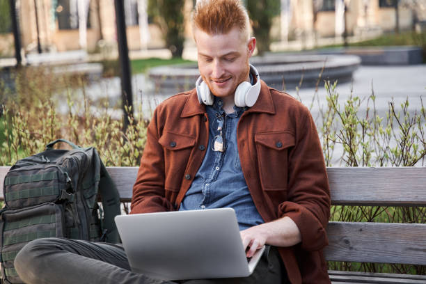 istock Programmer relaxing at the sunny street while browsing internet at the laptop 1325023497