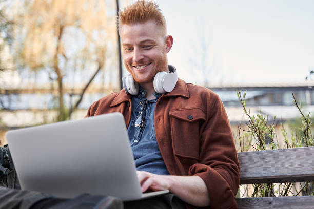 istock Programmer relaxing at the sunny street while browsing internet at the laptop 1325023531
