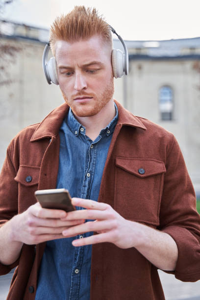 istock Man standing around the trees alone and listening music while spending weekend 1325023641
