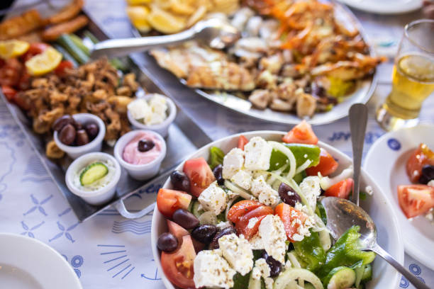 istock Greek salad in bowl and seafood on table 1325025799