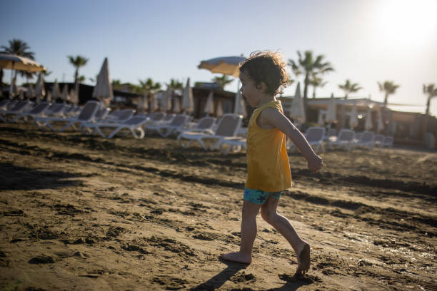 Little boy running on coastline during beach holiday, during coronavirus pandemic after reopening borders
