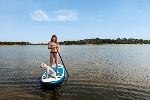 cute young girl paddle boarding on vacation