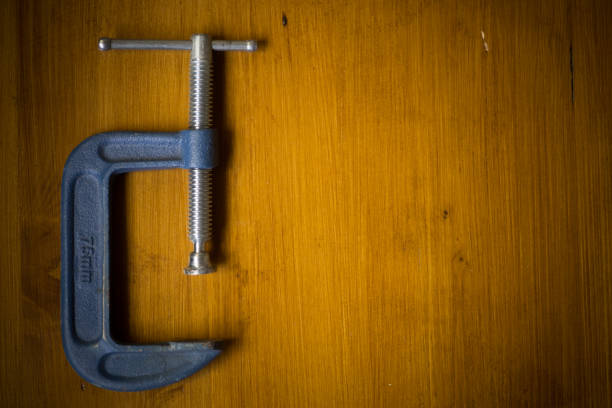 C clamp on a wooden background Close up shot of a c-clamp on a wooden background, with copy space to the right. c clamp photos stock pictures, royalty-free photos & images