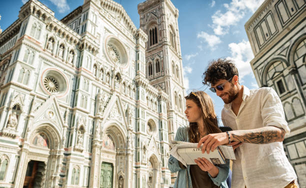 Couple of tourists in Florence, travelling around Italy A couple of tourists visiting Florence, in Italy, during a warm and sunny summer day. The guidebook is a stunt copy. florence italy stock pictures, royalty-free photos & images