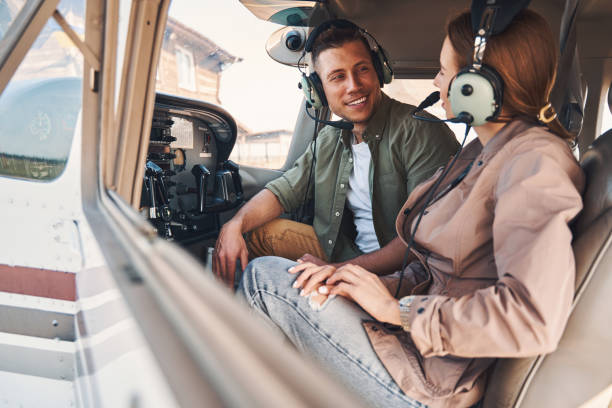 istock Joyful young man and woman sitting inside plane cockpit 1325031517