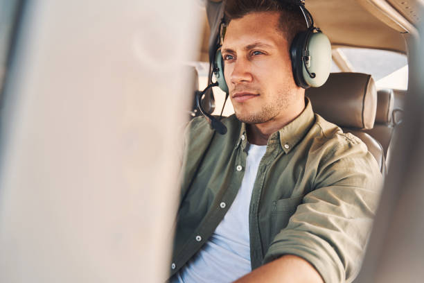 istock Handsome young man sitting in aircraft pilot cabin 1325031531