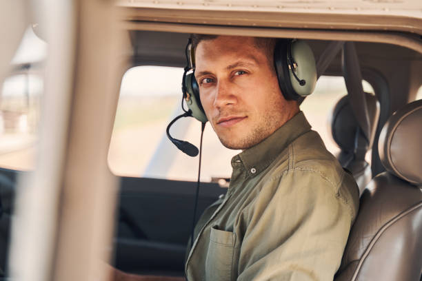 good-looking young man sitting inside plane cockpit - aviator glasses audio imagens e fotografias de stock