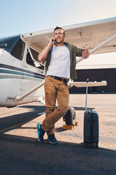 istock Cheerful young man talking on cellphone at airport 1325031601
