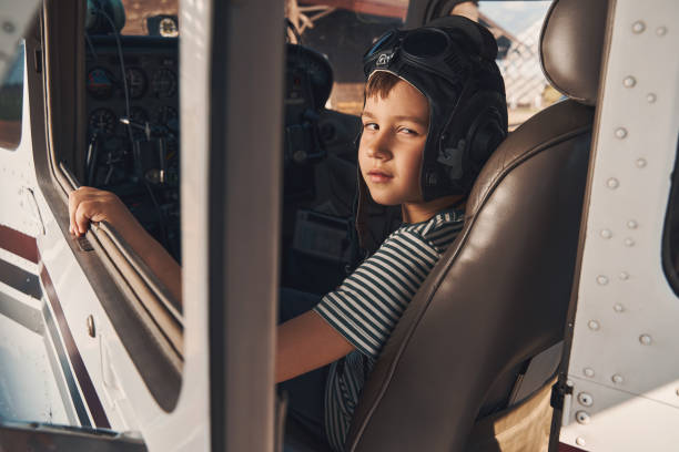 istock Adorable male child sitting inside airplane cockpit 1325031666