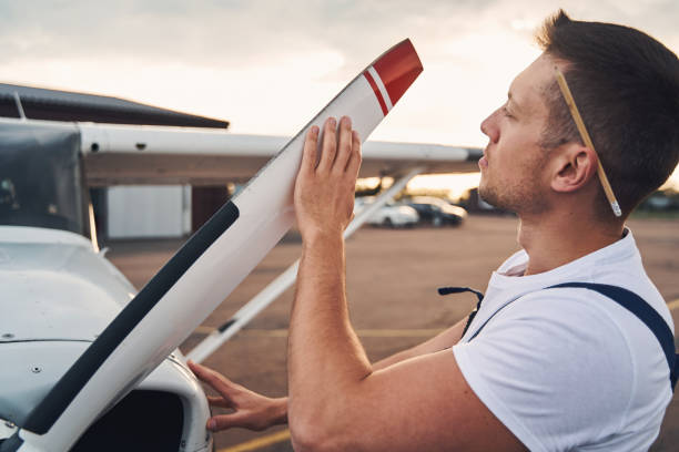 istock Male worker inspecting airplane propeller at aerodrome 1325031967