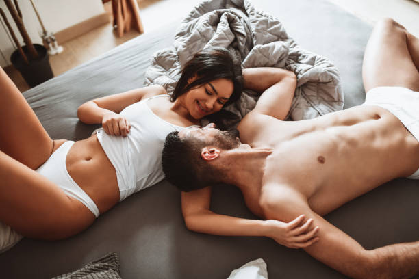 милая пара целоваться и проводить выходные в постели - sexual activity couple sensuality heat стоковые фото и изображения
