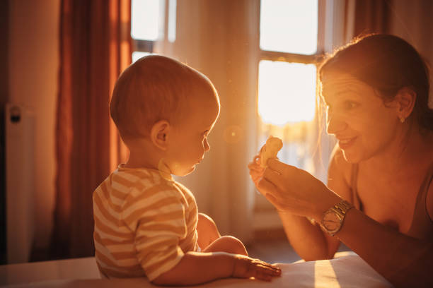 Two people, mother and her little son playing with toys together at home.