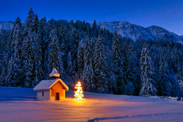 albero di natale illuminato nella cappella nel paesaggio invernale, baviera, germania - snow chapel christmas germany foto e immagini stock