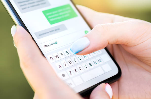 istock Text message with mobile phone. Woman texting sms with smartphone Catfish or digital scam. Screen keyboard in instant messaging chat. Macro close up of finger writing. 1325035692
