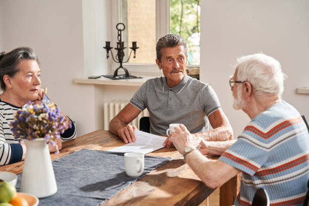 istock Senior people sitting at the table in front of each other and drinking tea 1325036154