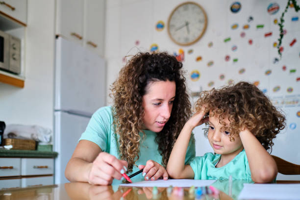 istock mother helps her son with his home school work at home 1325036287