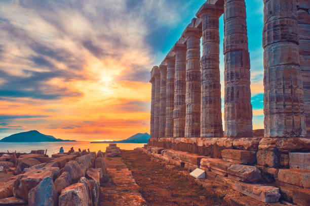 Poseidon temple ruins on Cape Sounio on sunset, Greece Greece Cape Sounio. Ruins of an ancient temple of Poseidon, Greek god of the sea, on sunset. Shot of temple ruins on sunset. Tourist landmark of Attica, Sounion, Greece headland stock pictures, royalty-free photos & images