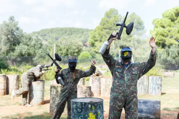 Photo of Paintball player standing raised arms
