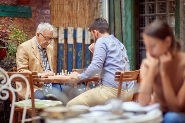 istock young and elderly man playing chess in outdoor cafe, thinking. 1325038908