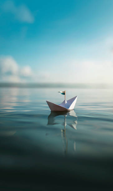istock Paper Boat sailing on turquoise Water 1325039496