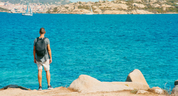 mann beobachtet die küste in sardinien, italien - insel caprera stock-fotos und bilder