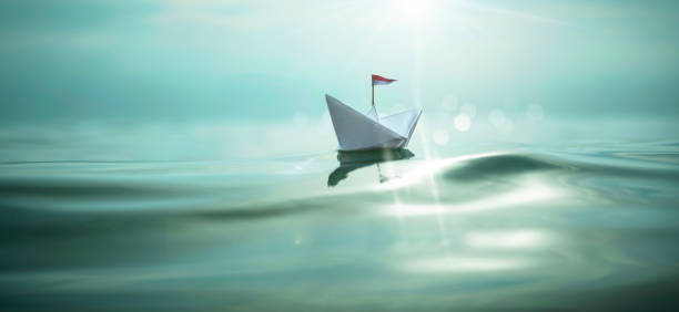 istock Paper Boat sailing on turquoise sunny water 1325040600
