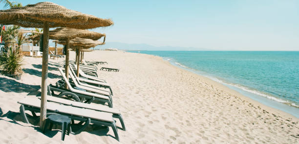 istock umbrellas and sunloungers on the beach, web banner 1325040623