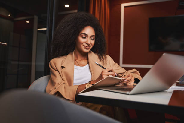 istock Mirthful lady making notes in the office and smiling 1325042121