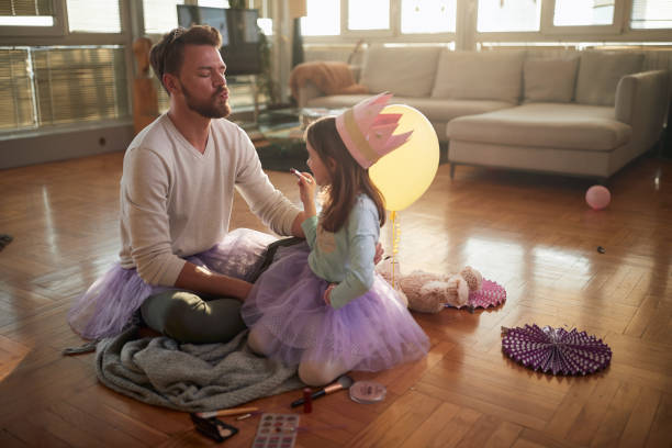 istock A young father waiting for his little daughter to put some lipstick on his lips while preparing for ballet practice at home. Family, together, home 1325043320