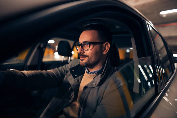 istock Attractive guy driving car at night 1325043702