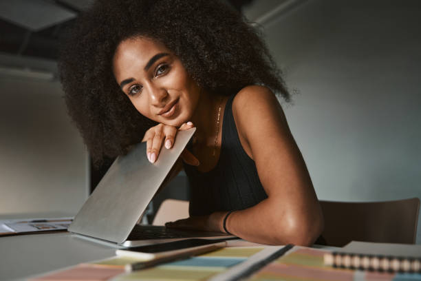 istock Attractive lady looking at you while sitting with gadget 1325044666